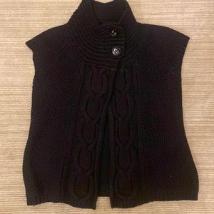 Black sleeveless vest by Jillian Jones.